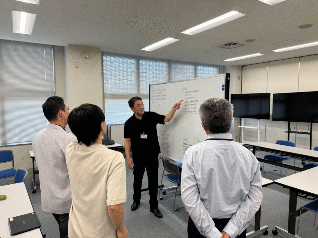講師の浅野氏と一緒にほわお糸ボードの板書を見る図