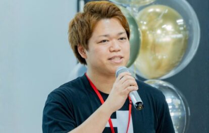 Tシャツ姿でマイクを持ち話をする西舘さん