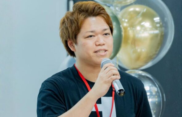 Tシャツ姿でマイクを持ち話をする西舘さん